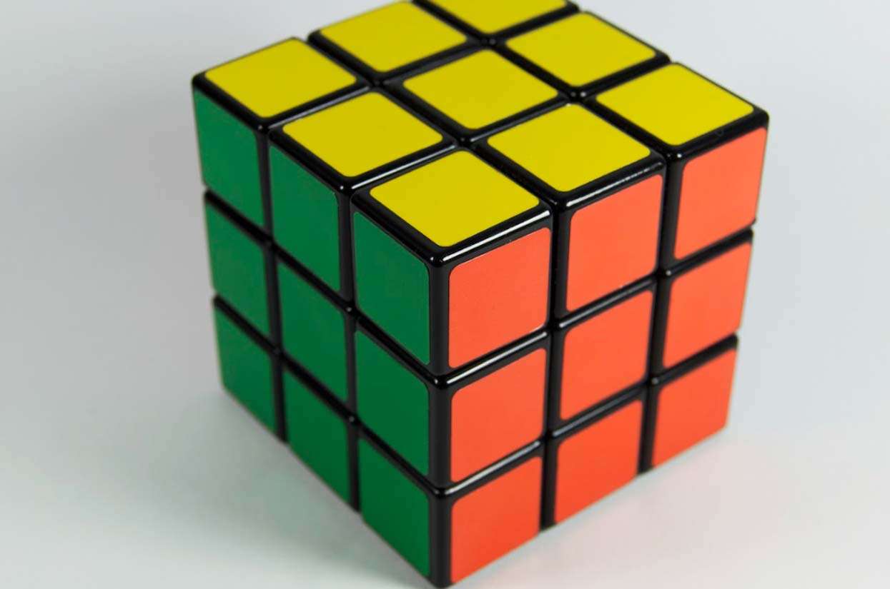 Rubik's Cube with yellow, green, red, and orange sides, representing problem-solving and strategy in brand building.
